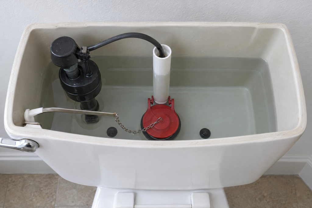 New toilet flapper installed inside a residential toilet tank with clear water